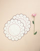 Set of two flower shaped placemats in white with embroidered bordeaux borders and embroidered dot details