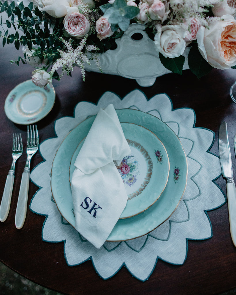 Table Setting with Napkin with embroidered initials on top of a blue Plate standing on a star shaped embroidered placemat
