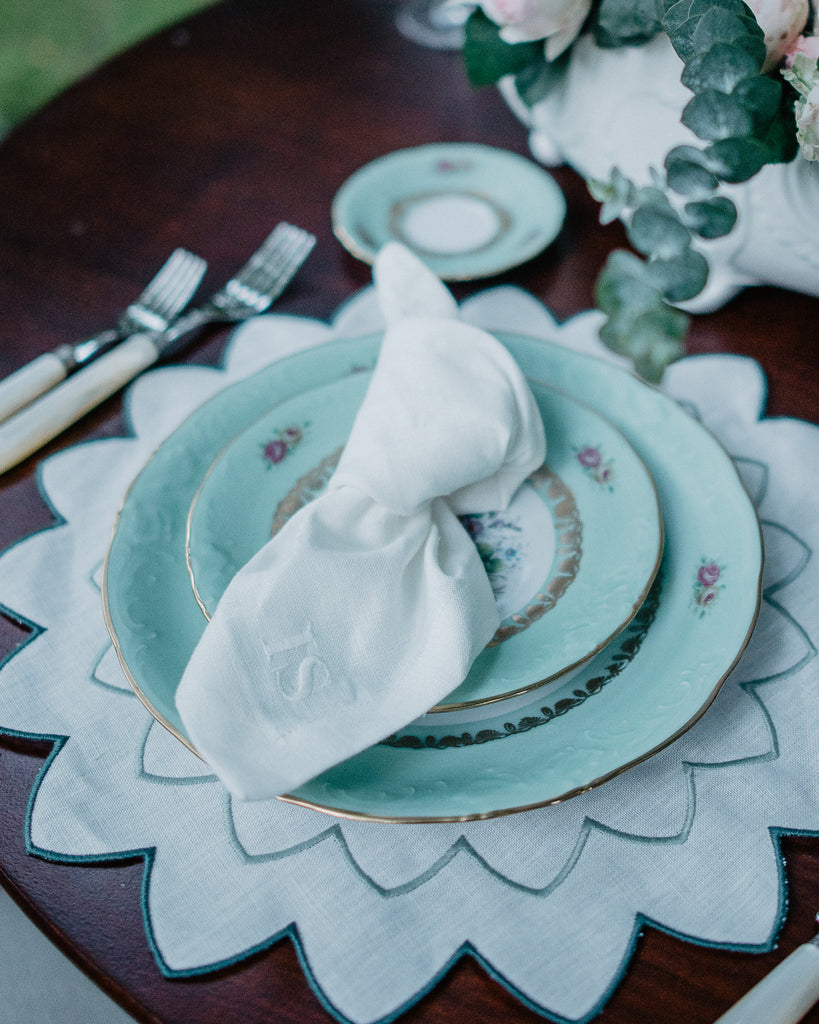 Table Setting with Napkin with embroidered initials on top of a blue Plate standing on a star shaped embroidered placemat