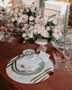 Flowery table setting, with a matching set of napkins and placemats in white, with bordeaux embroidered borders, and a bordeaux scarab and green foliage embroidered in each